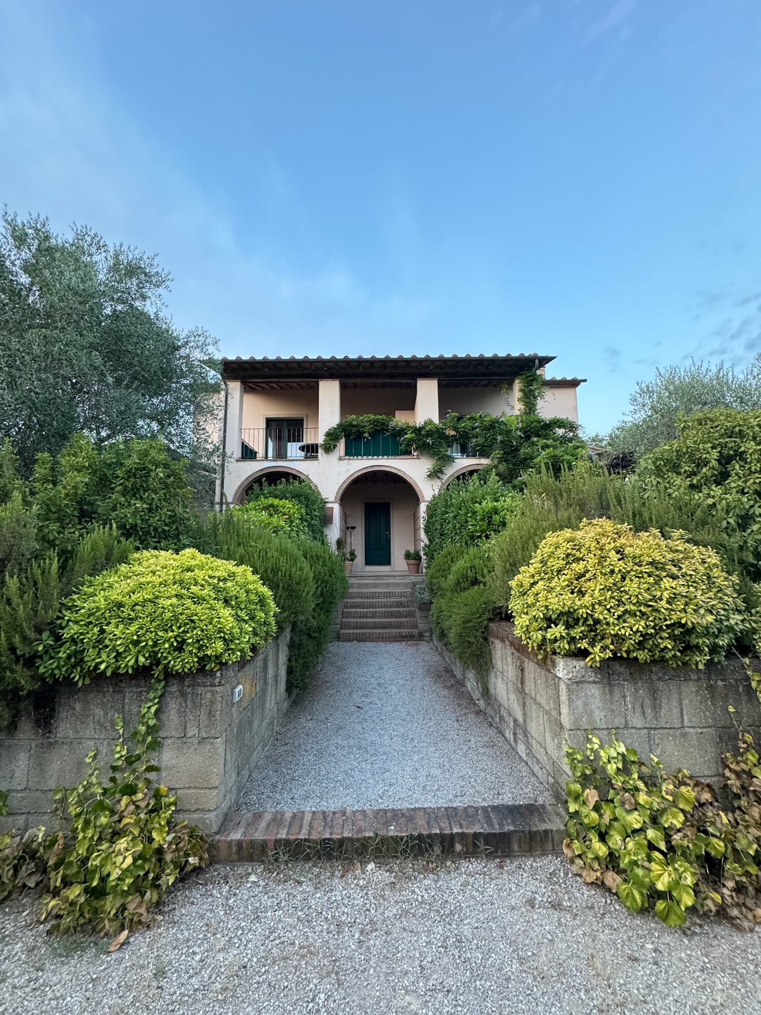 Fassade mit Arkaden, Treppe und mediterranem Garten