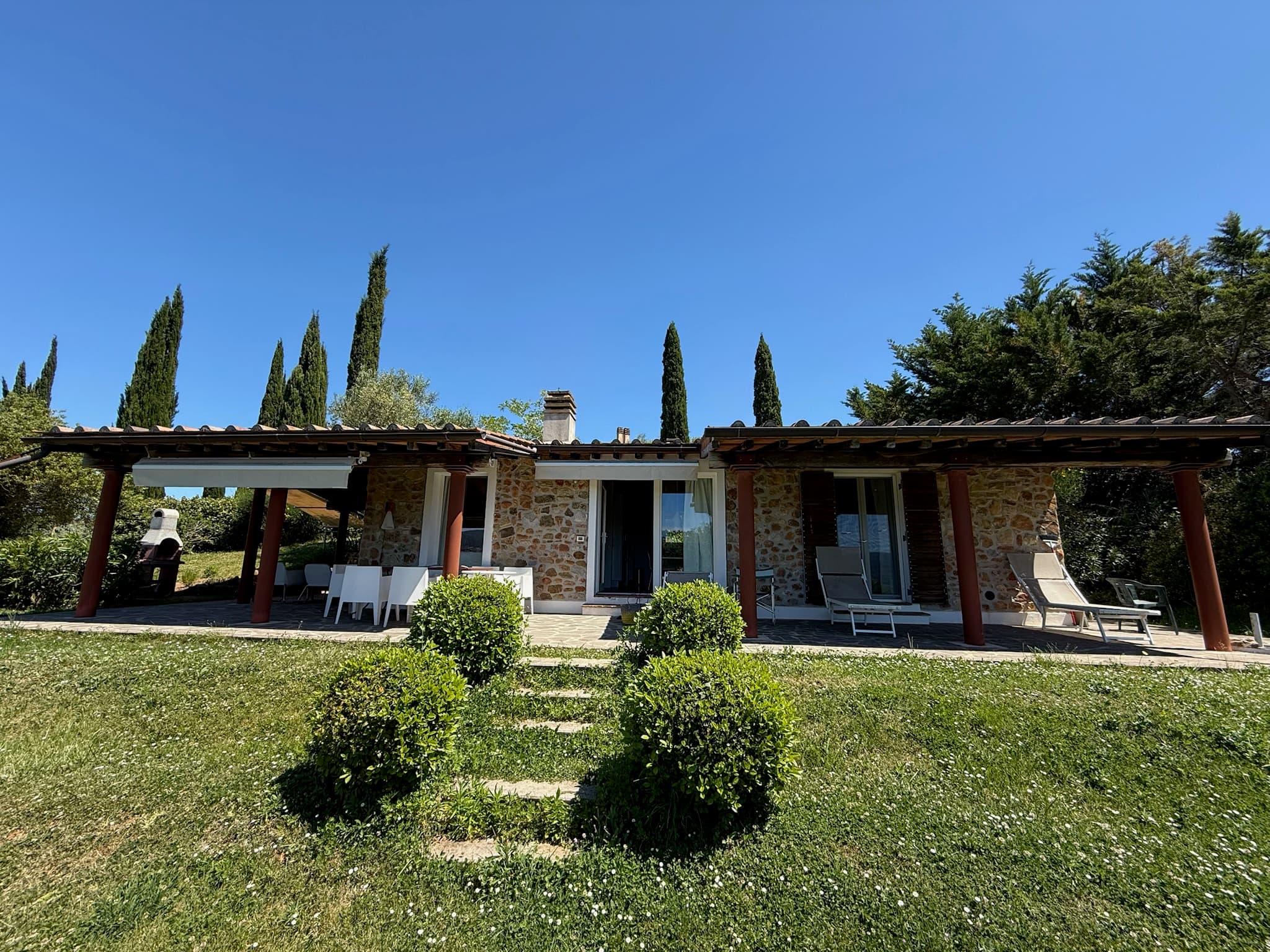 Freistehendes Haus Tirli mit langem Portico und Zypressen im Garten