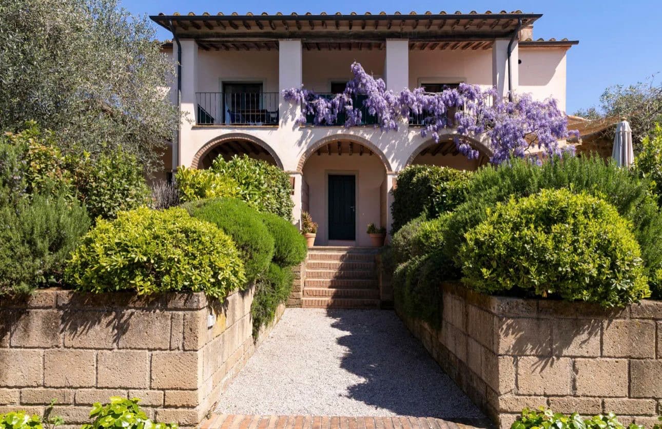 Facciata dell’appartamento Vetulonia al primo piano con glicine in fiore e balcone