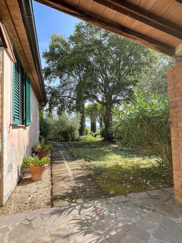Blick vom Portico der Wohnung Grilli in den Garten, Pfirsichfassade und grüne Fensterläden